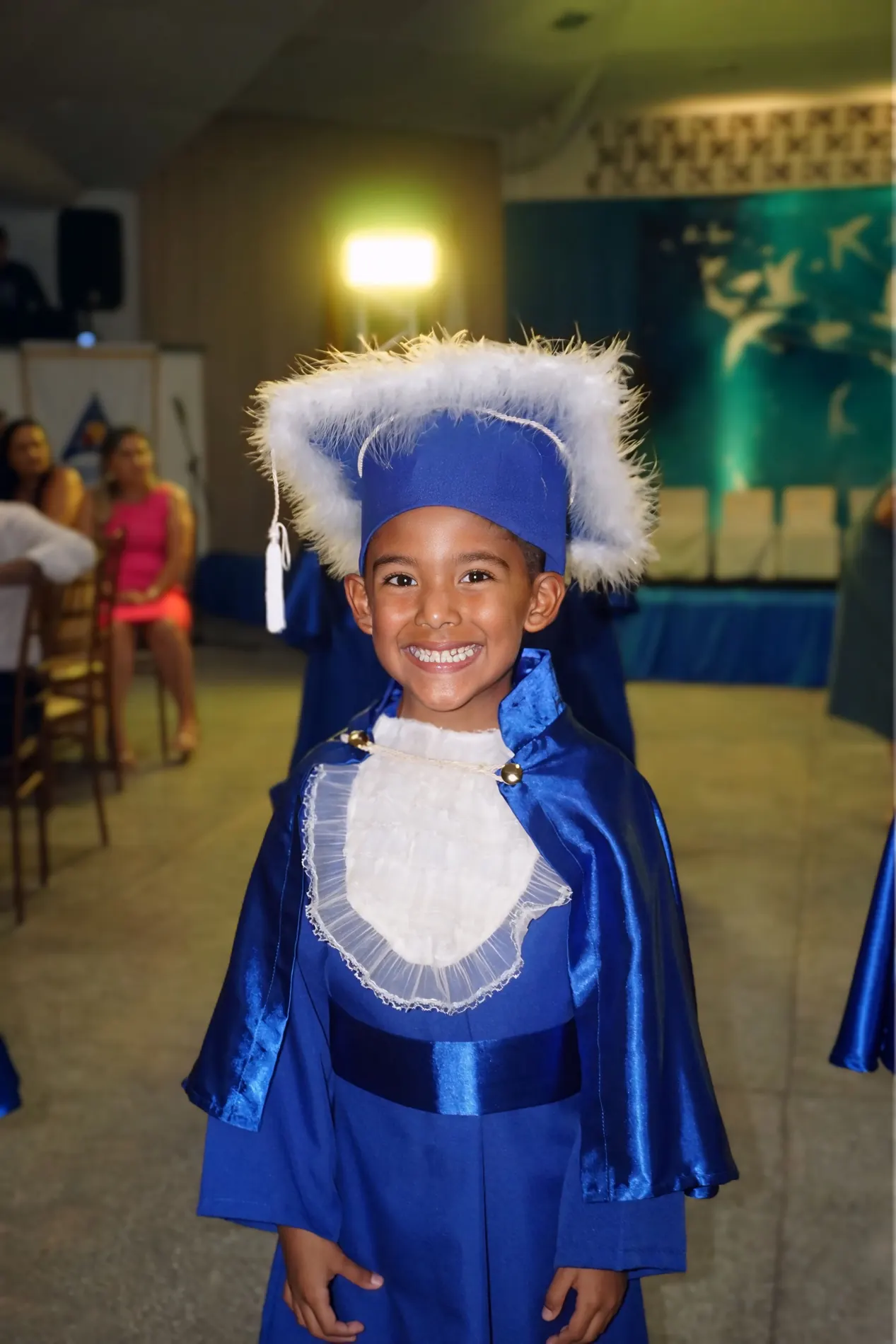 Formando da Educação Infantil do Colégio Cefron com beca e capelo