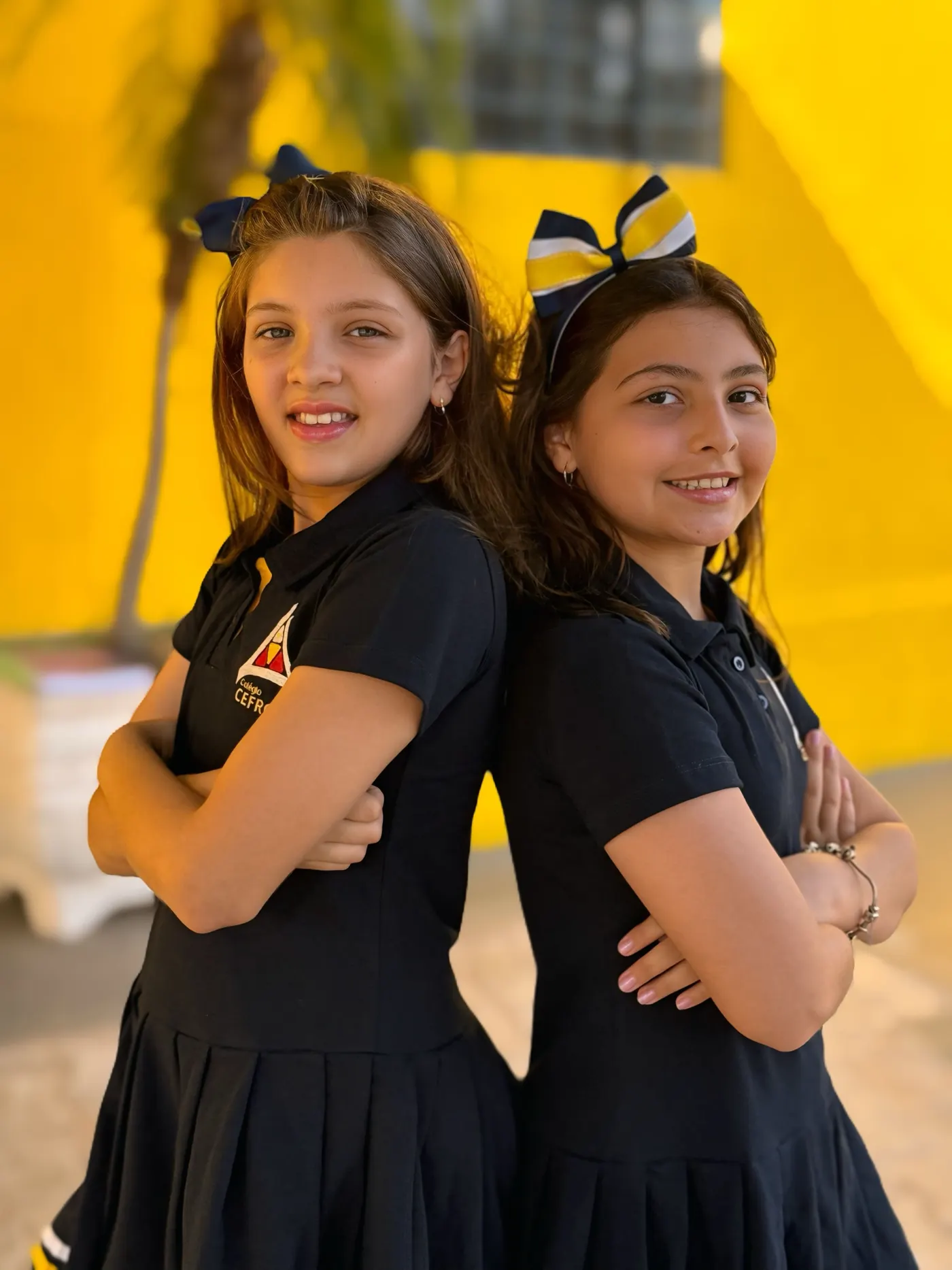 Duas alunas do Colégio Cefron uniformizadas no pátio da escola