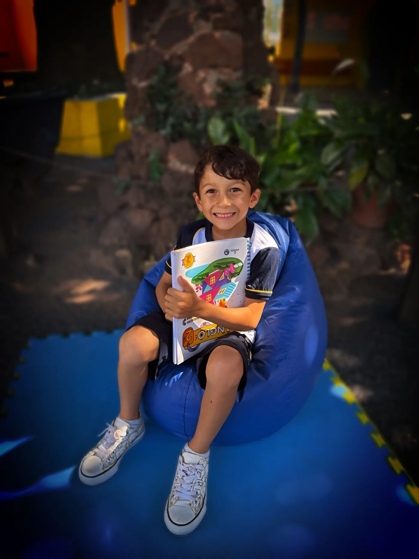 Aluno do Colégio Cefron lendo o material didático no pátio da escola