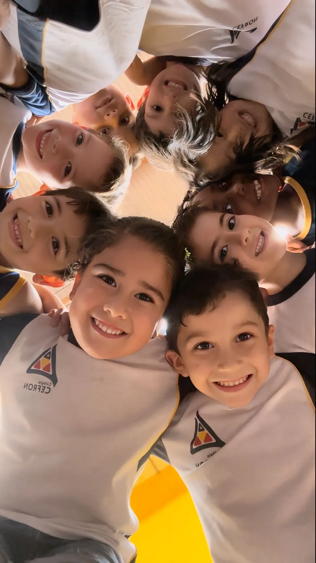 Alunos do Colégio Cefron reunidos em roda, sorrindo para a câmera